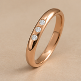 Alianza media caña oro rosa 18k con tres diamantes, vista oblicua