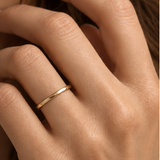 Alianza Plana Pure en oro amarillo de 18k puesta en la mano - imagen editorial